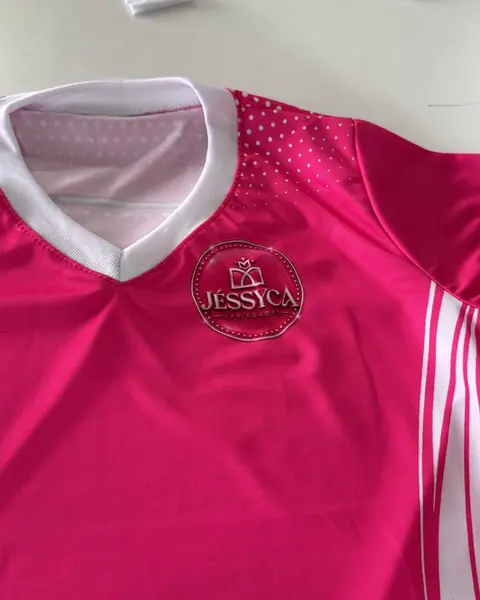 Camisa rosa com detalhes brancos e o logo Jessyca no peito